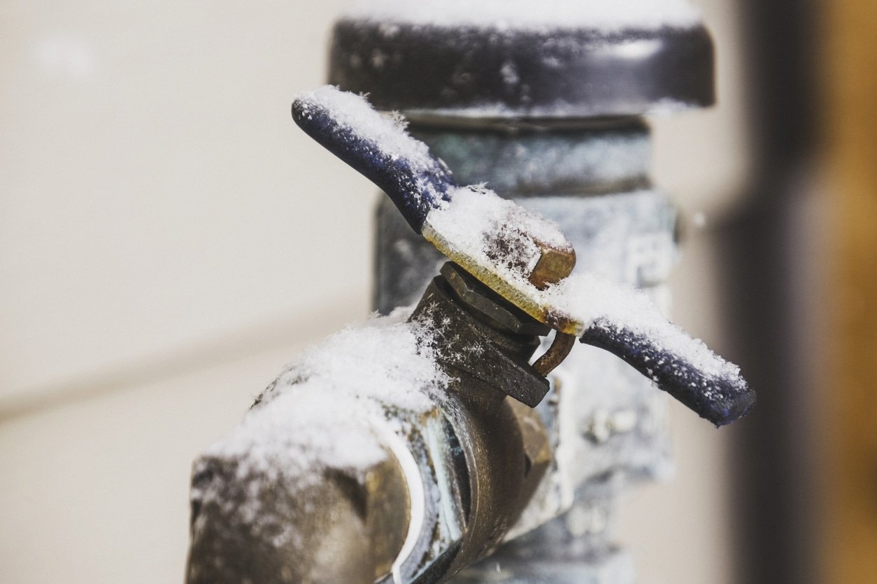 Home's water shut off handle frozen during the winter season - showing a concept of probable winter plumbing issues.