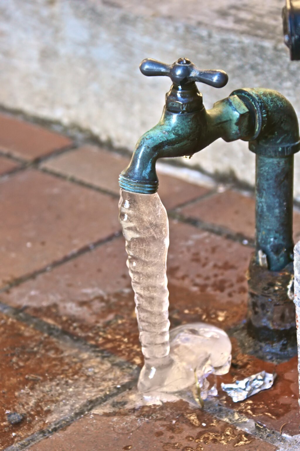 A frozen hose spigot outside a house.