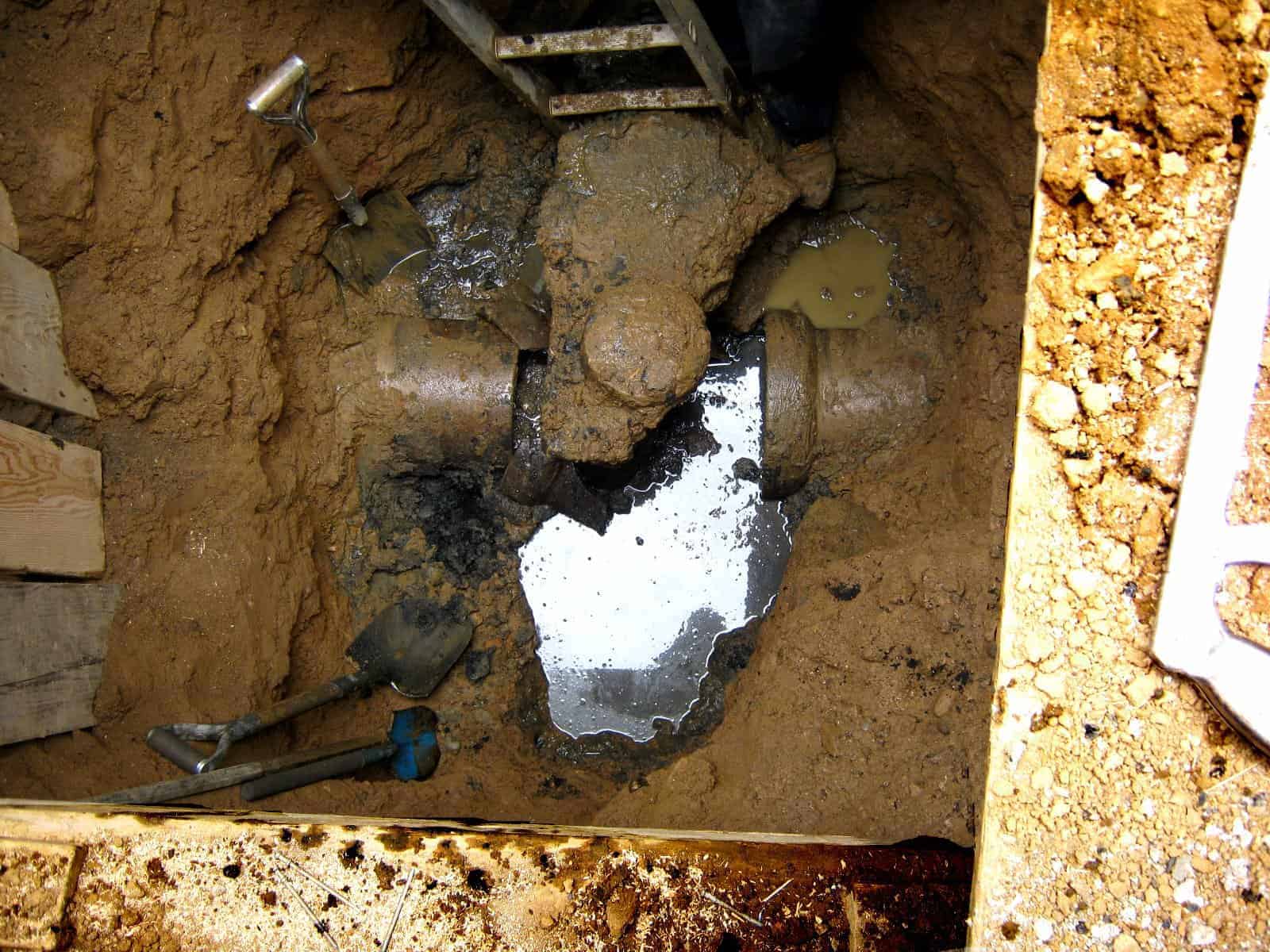 Sewer line collapsed caused by heavy pressure - A damaged  sewer line surrounded by soil.